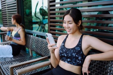 Güzel, sağlıklı bir kadın. Egzersiz yaptıktan sonra dinlenme odasında konuşuyor..