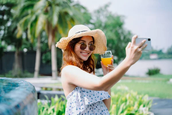 아름다운 아시아 여행자가 오렌지 복용하는 모자와 선글라스를 — 스톡 사진