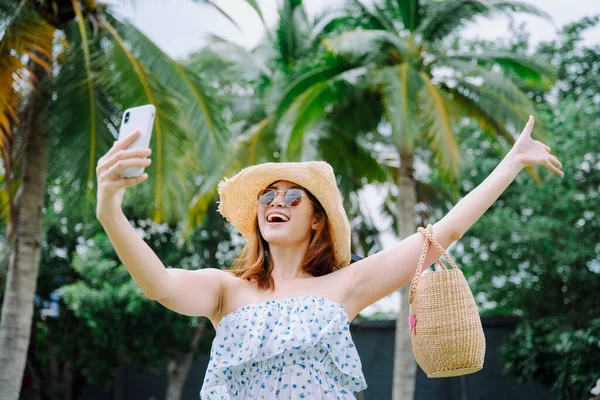 美丽的亚洲女人带着帽子和太阳镜带着智能手机旅行博客 — 图库照片