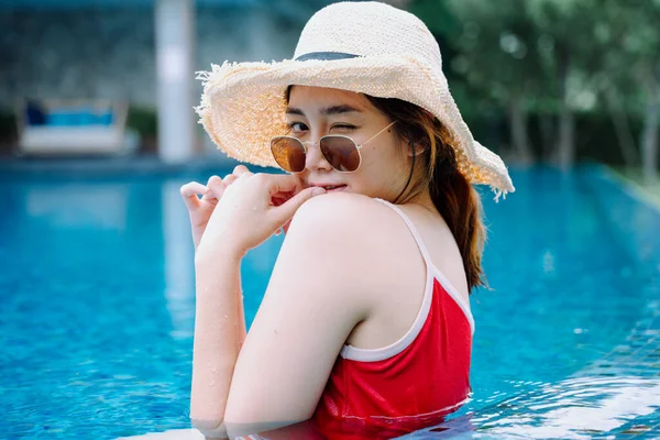 美しいアジアの女性旅行者はサングラスをかけ 帽子はスイミングプールでリラックス — ストック写真