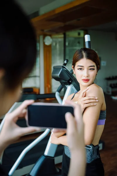 健身馆用智能手机拍照的健康美女 — 图库照片