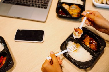 Üst Manzara - Ofiste çalışırken iş adamları beslenme çantası seti yiyor.