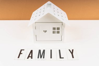 Masadaki aile için oyuncak bir beyaz ev.