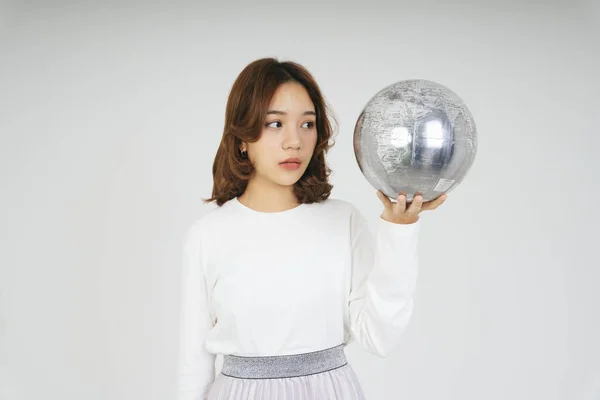 Young asian woman with silver globe ball isolate on white background.