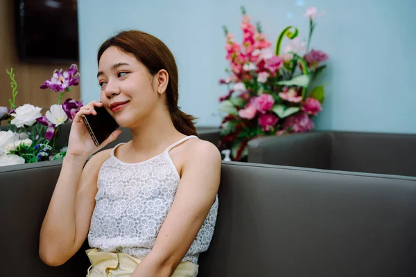 미용실에 들어가기 스마트폰으로 친구에게 조언을 구하는 아시아 — 스톡 사진