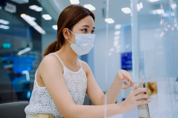 美しいアジアの女性は 彼女が外科的プロセスの前に見たいもののためにスタッフに電話で写真を示すマスクを着用 — ストック写真