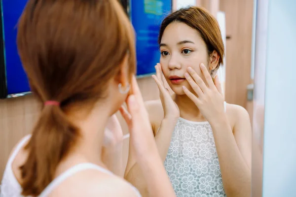 Азиатка Смотрящая Зеркало Свое Лицо После Процедуры Уходу Лицом Клинике — стоковое фото