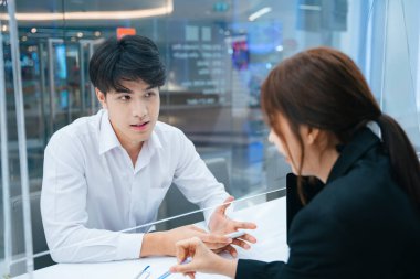 Asyalı genç adam danışma danışmanıyla konuşuyor..