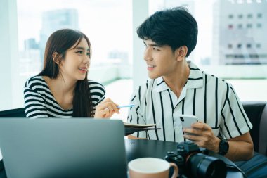 İki Asyalı etkileyici bilgisayar laptopuyla canlı video yayını yapıyor..