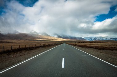 Soldaki otoyol, bulutların biriktiği ve kar yağışı olan bir dağ aralığıdır..