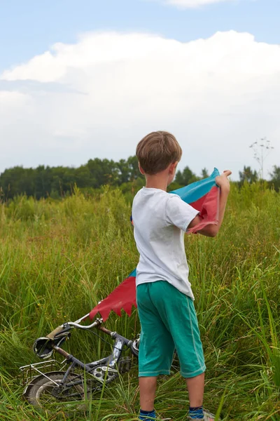 Adam havaya uçan uçurtma başlatmak çalışır. Renkli ışık uçan makine.