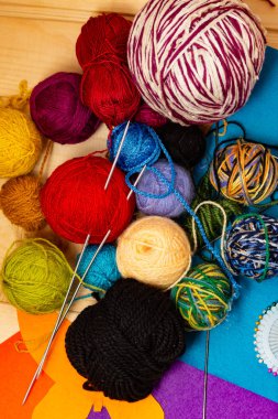 Renkli patchwork kumaş. İş parçacığının çok renkli yün topları. Ev örgü örgü iğneleri. Biriktiricileri için dikiş iğne ve iplik ile tabut. Natürmort ahşap arka plan üzerinde.