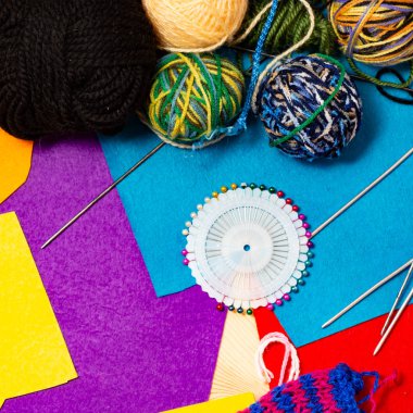 Renkli patchwork kumaş. İş parçacığının çok renkli yün topları. Ev örgü örgü iğneleri. Biriktiricileri için dikiş iğne ve iplik ile tabut. Natürmort ahşap arka plan üzerinde.