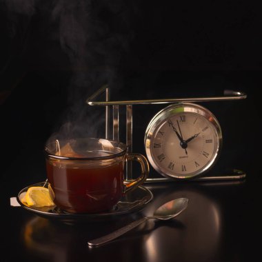 Şeffaf cam çay içecek ile. Tonlama, canlandırıcı, sabah sıvı. İçmek için maddelerinin bir siyah arka plan üzerine.