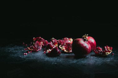painted organic red pomegranates on black with copy space  clipart