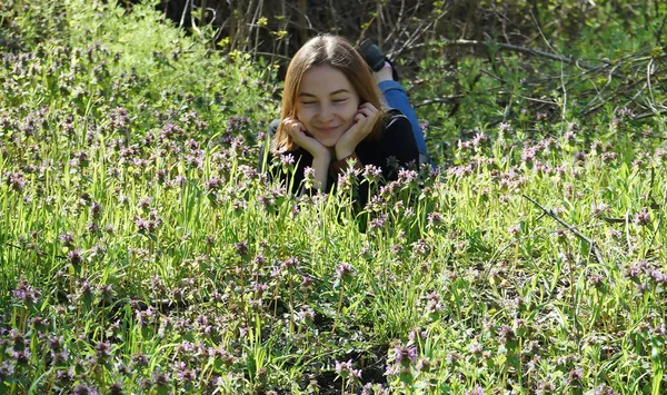 Mooi jong meisje liggend op de rand van het bos, leven met de natuur — Stockfoto
