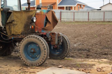 bir avluda eski paslı yıpranmış traktör