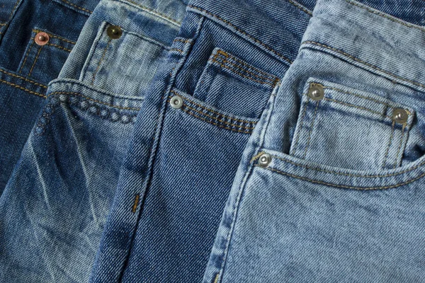 Blauwe jeans broek kleren stapel achtergrond. Stapel spijkerbroek op winkel Bureau — Stockfoto