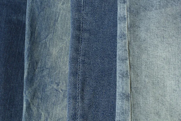 Azul jeans diferentes sombras pantalones ropa pila fondo. Pila de jeans azules en el escritorio de la tienda — Foto de Stock