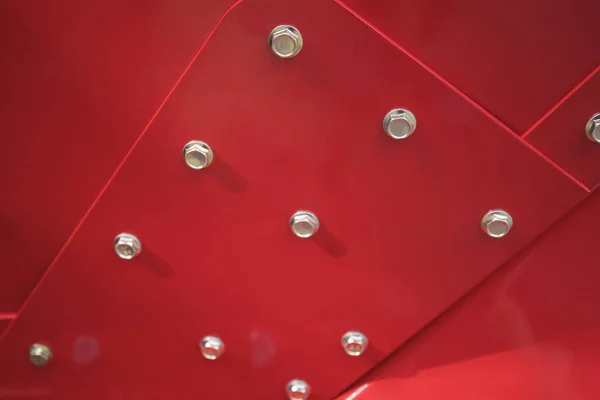 빨간색으로 칠해진 철벽에 볼트와 너트를 닫습니다. — 스톡 사진