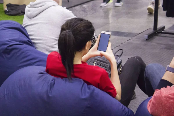 Akıllı bir telefonla medyada rahatlayan bir kadının arka planı.