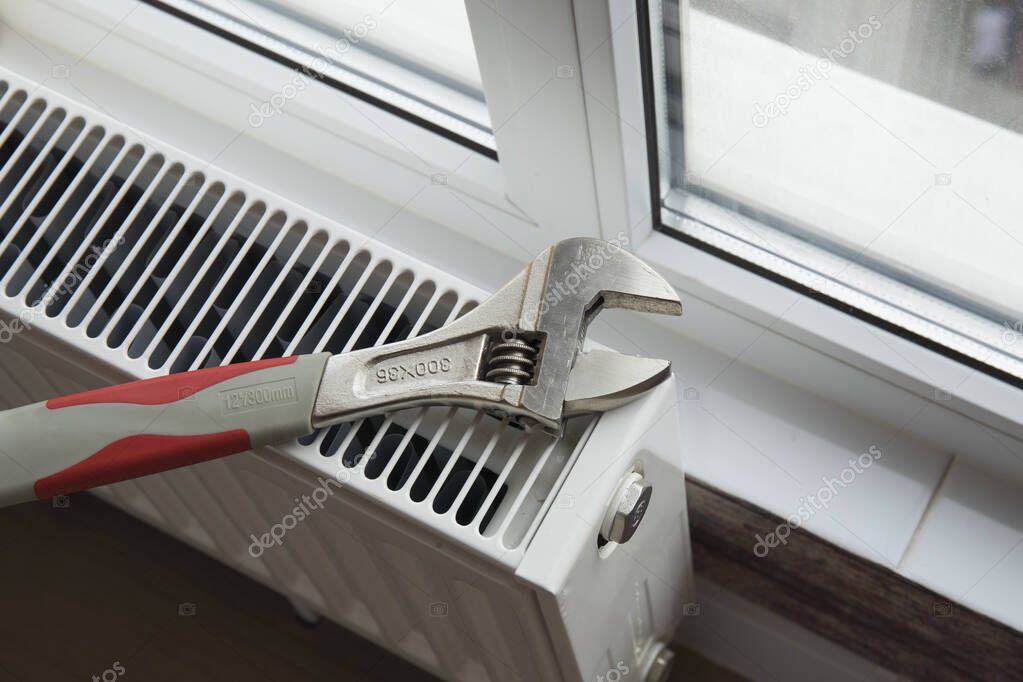 Adjustable wrench on the heating radiator