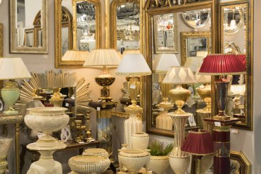 Mobilya mağazasındaki farklı modern güzel lambalar ve aynaların resmi.