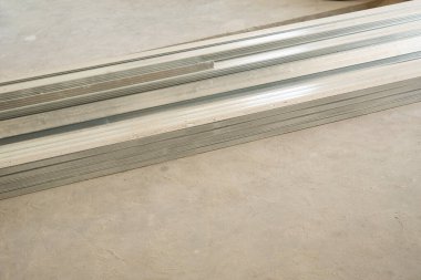 Gri beton zeminde alçıpan metalik profili