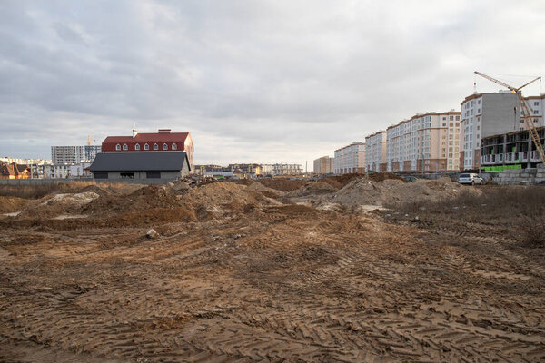 View on construction place with dirt land and unfinished houses