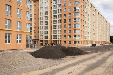 Toprak arazisi ve bitmemiş evleri olan inşaat alanına bak.