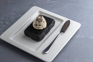 Beyaz tabak, tereyağı için spatula. Yaratıcı servis yemekleri üst görünümü. Gri arka plan