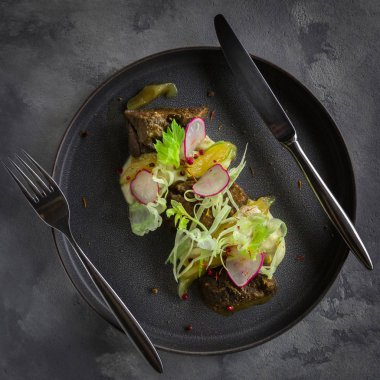 Restoranda gri arka plan üzerinde kereviz püresi ve zencefil armut ile Sırlı Beef Cheek