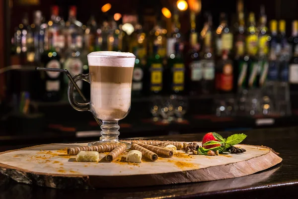 Close-up café irlandês em vidro transparente no balcão de madeira bar. Fundo borrado e garrafas de restaurante . — Fotografia de Stock