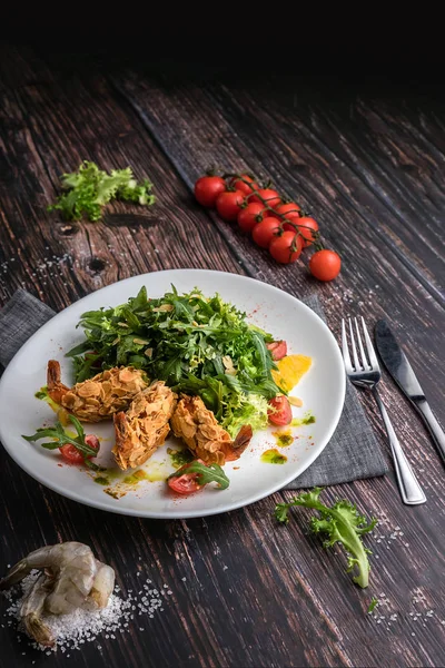 Prato de salada fresca com camarão, tomate, arugula, laranja sobre fundo escuro de madeira perto. Conceito de comida saudável em estilo rústico — Fotografia de Stock