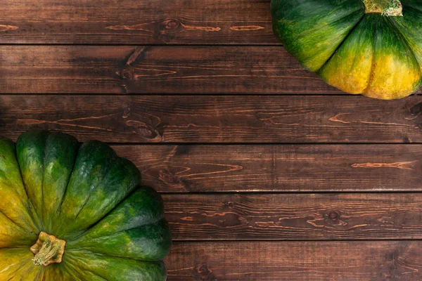 Composição de outono com abóboras verdes, amarelas, vermelhas e laranja no fundo de madeira marrom. Flat lay, vista superior, espaço de cópia — Fotografia de Stock