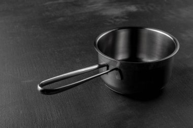 Siyah çimento arka planda gümüş metal tava. desenli granit yüzey ve çatal bıçak