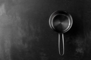 Siyah çimento arka planda gümüş metal tava. Metin üstü görünümün için kopyalama alanı ile şablon. granit çatalının dokulu yüzeyi