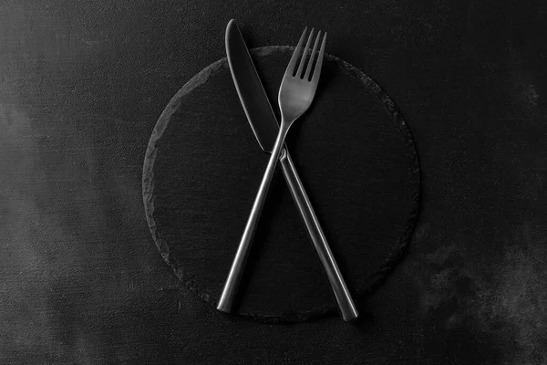 Empty Black Stone Board Crossed Cutlery Knife Fork Black Cement — Stock Photo, Image