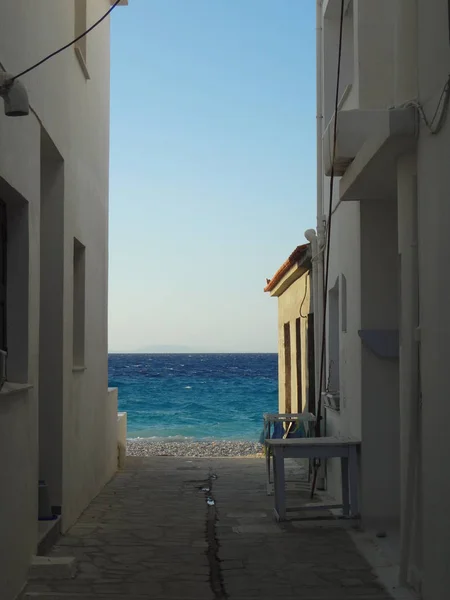 View on the blue sea through a narrow street — Stock Photo, Image