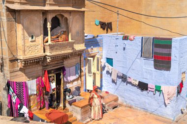 Jaisalmer/India-13.07.2019:Women drying her wet clothes clipart