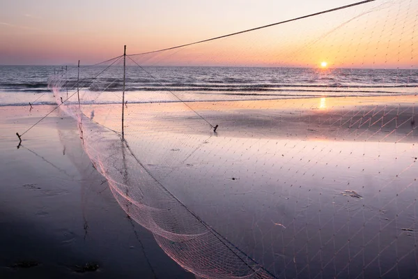 Seaside with fisherman net and sunset