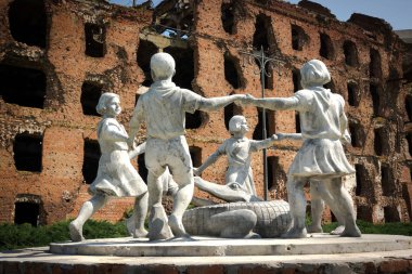 Volgograd, Russia - June 18, 2016: Statue of circle of kids and crocodile and destroyed building. clipart