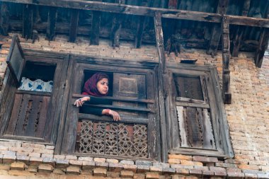 Bhaktapur, Nepal - 19 Mart 2019:Pencereden bakan yong kadın
