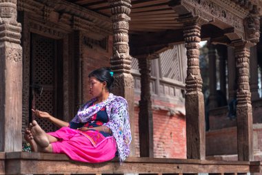 Katmandu, Nepal - 18 Mart 2019: Katmandu'da Durbar meydanında oturan kadın