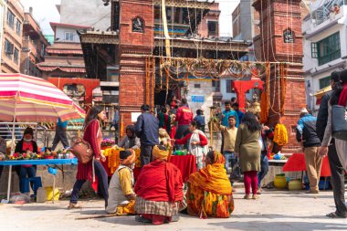 Katmandu, Nepal - 18 Mart 2019: Katmandu'daki Durbar Meydanı'nda tapınağın yanında oturan dilenciler