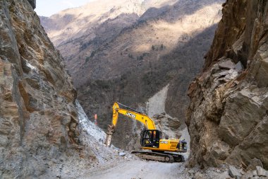 Tatopani, Nepal - March 11,2019: Road blocked by landslide. Excavator at work. clipart