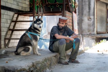 Tosh, Hindistan - 21 Ekim 2018: Hintli adam ve husky köpek