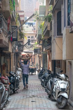 Amritsar, Hindistan - 28 Ekim 2018: Başında tuğla taşıyan adam
