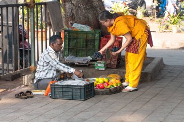 Mumbai, Hindistan - Juary 16, 2019: Hintli kadına meyve satan adam