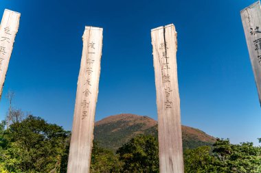 Lantau Zirvesi yakınlarındaki Bilgelik Yolu. Tercümesi: Vücut boşluktan başka bir şey değildir, boşluk vücuttan başka bir şey değildir. Vücut tamamen boştur, ve boşluk da tam olarak vücuttur..